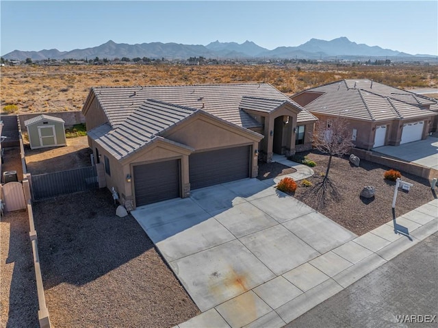 view of front facade featuring a tile roof, a mountain view, and concrete driveway