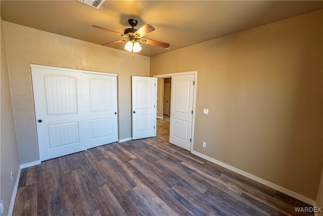 unfurnished bedroom featuring visible vents, baseboards, ceiling fan, dark wood-style flooring, and a closet