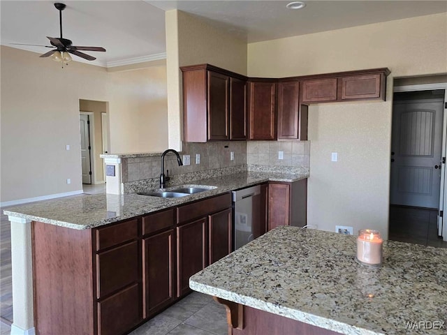 kitchen with light stone countertops, a peninsula, a sink, stainless steel dishwasher, and decorative backsplash