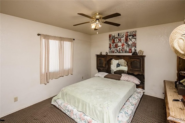 bedroom with dark colored carpet and a ceiling fan