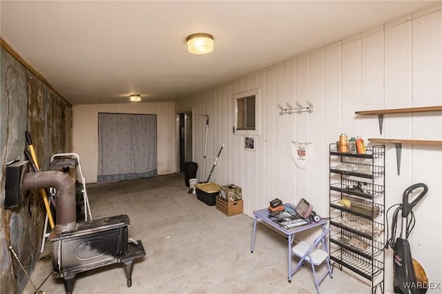 misc room featuring a wood stove and concrete floors