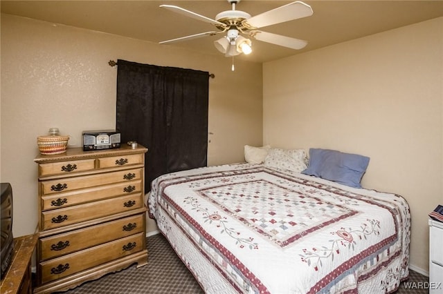 bedroom with dark colored carpet and a ceiling fan