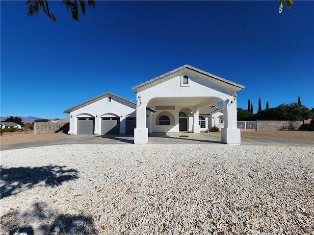 view of front of home with a garage, fence, concrete driveway, and stucco siding