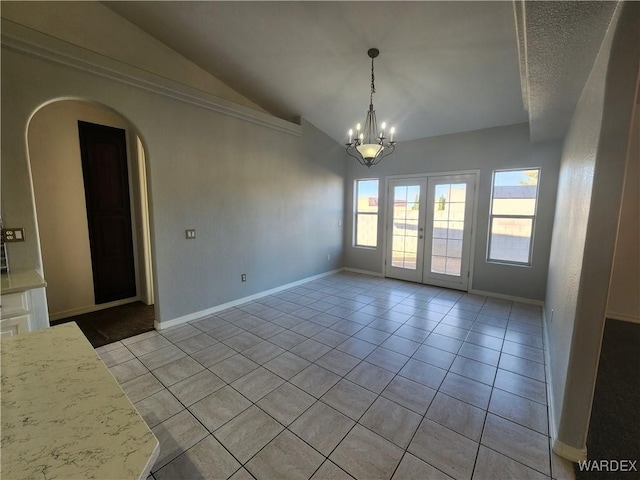 unfurnished room with light tile patterned floors, baseboards, arched walkways, vaulted ceiling, and a notable chandelier