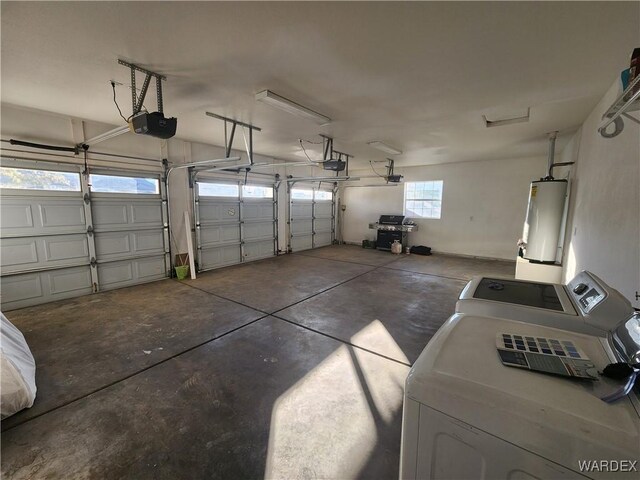 garage with gas water heater, washing machine and clothes dryer, and a garage door opener