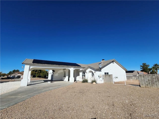 back of property with a gate, fence, and stucco siding