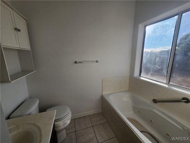 bathroom featuring a whirlpool tub, plenty of natural light, a sink, and toilet