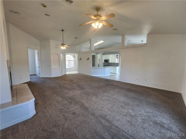 unfurnished living room featuring high vaulted ceiling, dark colored carpet, and a ceiling fan