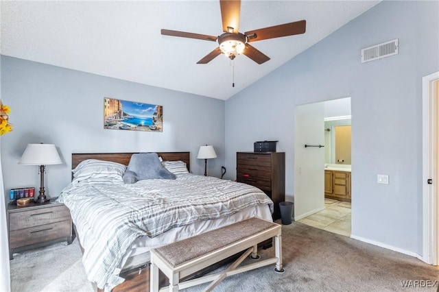 bedroom featuring light colored carpet, visible vents, connected bathroom, vaulted ceiling, and baseboards