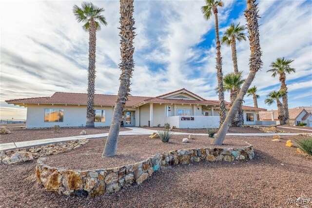 view of front of home with driveway, a tile roof, and stucco siding