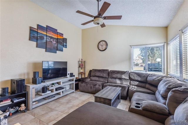 living area featuring light tile patterned flooring, vaulted ceiling, a textured ceiling, and ceiling fan