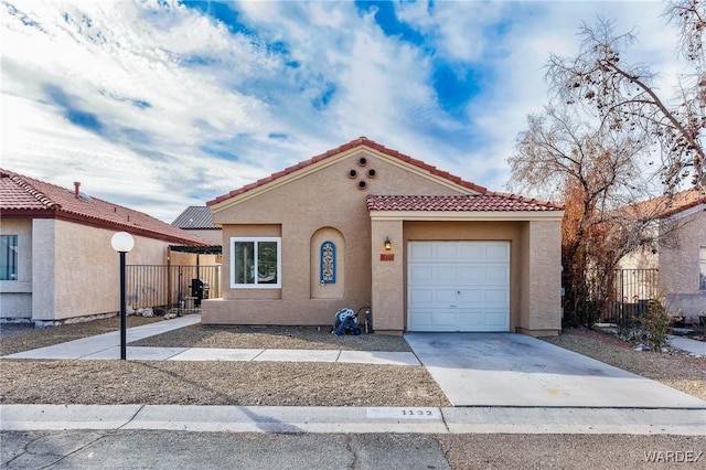 mediterranean / spanish home with an attached garage, a tile roof, fence, driveway, and stucco siding