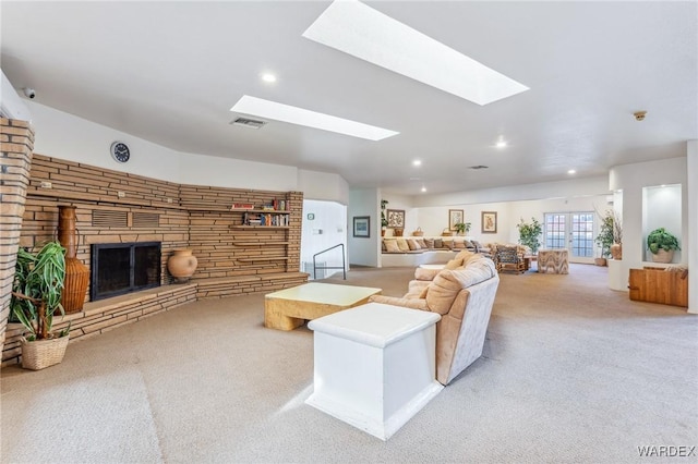 living area featuring carpet floors, recessed lighting, visible vents, and a stone fireplace