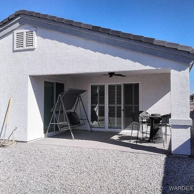 back of property featuring a ceiling fan, a patio, and stucco siding