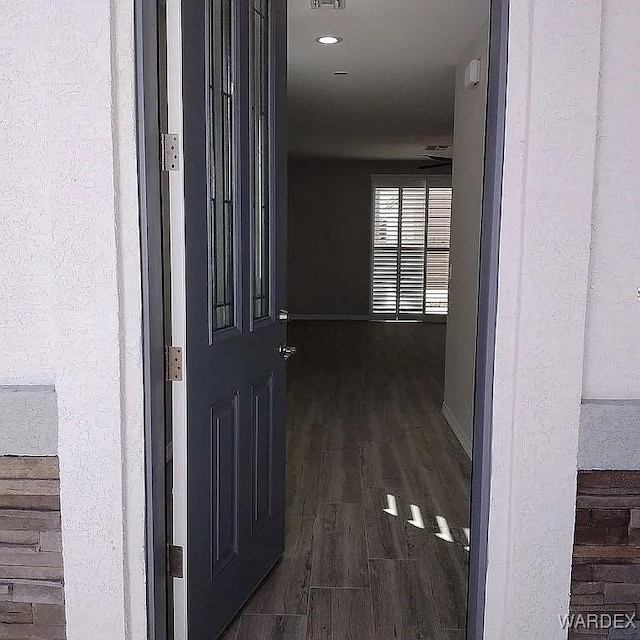 corridor with dark wood finished floors and baseboards