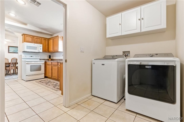 washroom featuring laundry area, light tile patterned floors, visible vents, baseboards, and washing machine and dryer