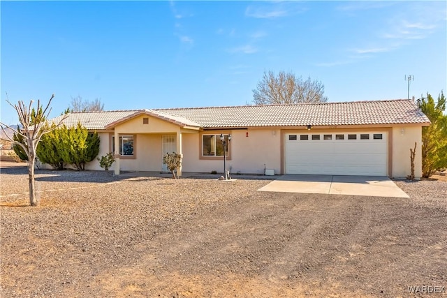 ranch-style house with driveway, an attached garage, a tiled roof, and stucco siding