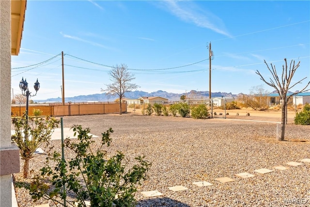 view of yard featuring a mountain view and fence