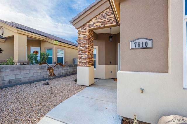 entrance to property with stone siding and stucco siding