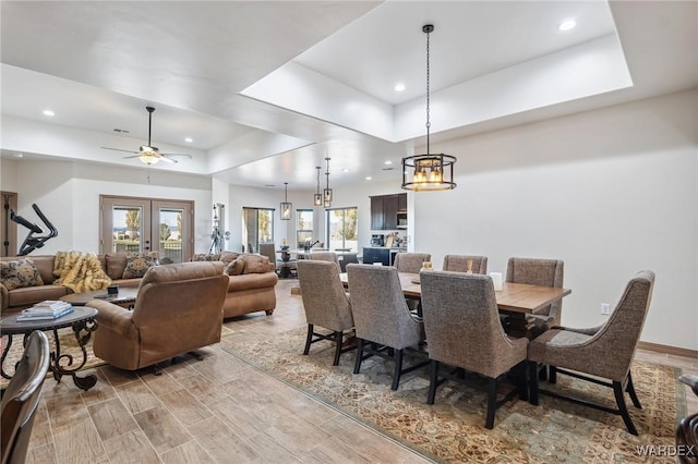 dining area featuring french doors, a tray ceiling, wood tiled floor, and recessed lighting