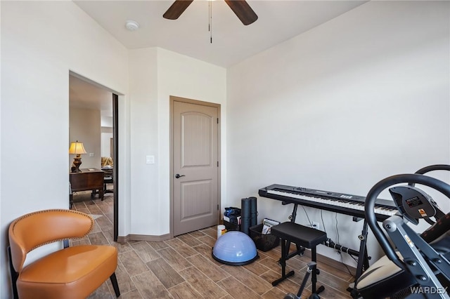 workout room with baseboards, a ceiling fan, and wood finish floors