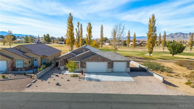 ranch-style house featuring an attached garage, driveway, and a mountain view