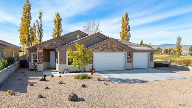 ranch-style home with driveway, a garage, a tiled roof, a mountain view, and stucco siding