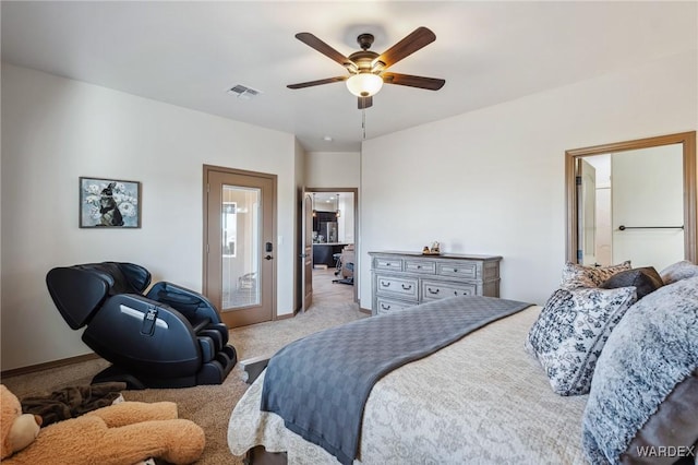 bedroom featuring light carpet, baseboards, visible vents, a ceiling fan, and ensuite bath