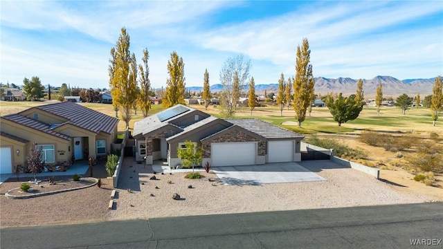 view of front of property featuring a garage, a mountain view, and concrete driveway