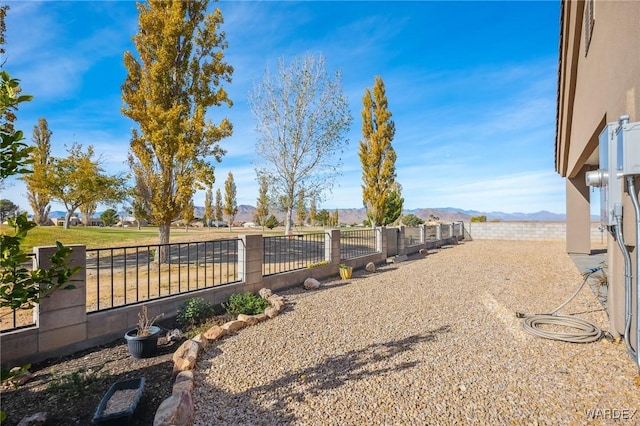 view of yard with a fenced backyard and a mountain view