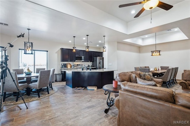 living area featuring visible vents, recessed lighting, a ceiling fan, and light wood-style floors