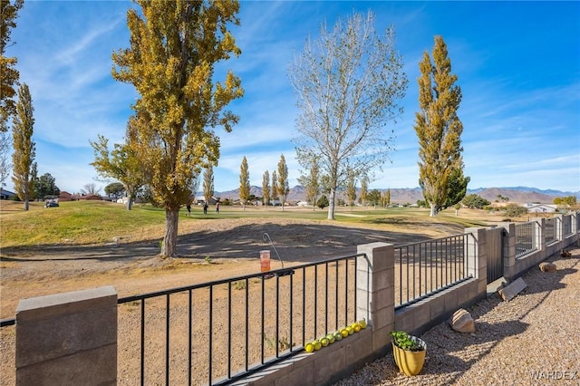 exterior space with fence, a mountain view, and a yard