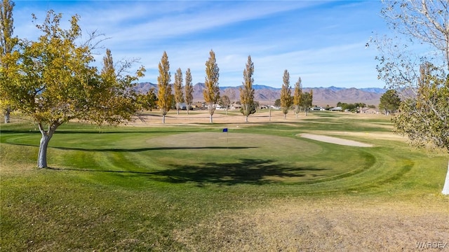 surrounding community featuring a yard, golf course view, and a mountain view