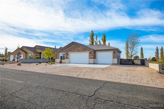 view of front facade with driveway, an attached garage, fence, and stucco siding