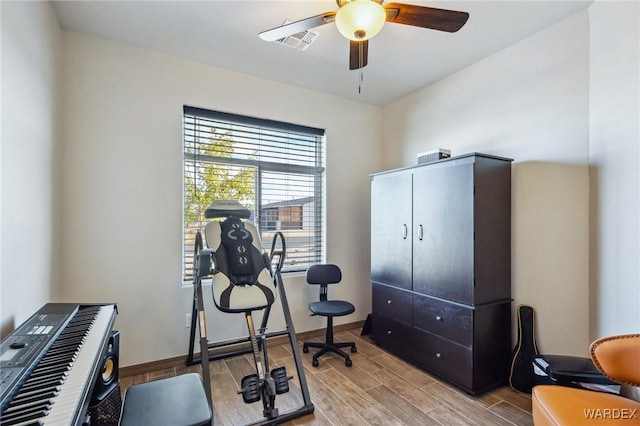 workout room with a ceiling fan, wood finish floors, visible vents, and baseboards