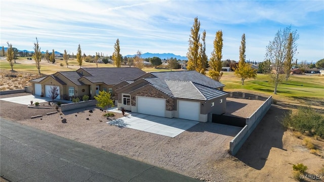 single story home featuring an attached garage, a tile roof, a mountain view, and concrete driveway