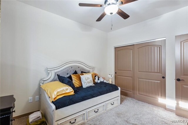 bedroom with light carpet, ceiling fan, and a closet