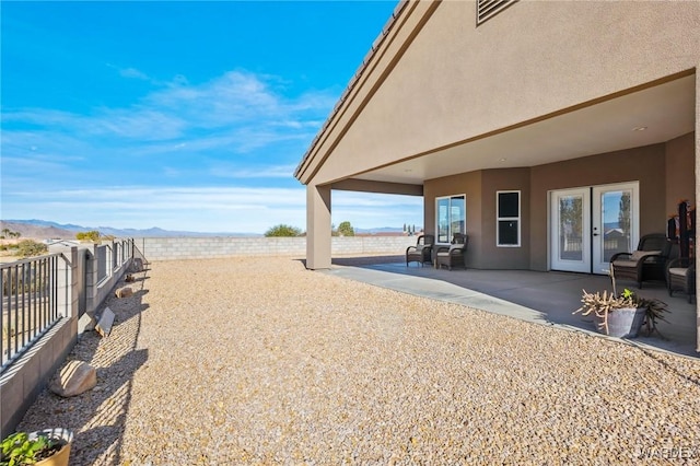 view of yard featuring a fenced backyard, a mountain view, and a patio