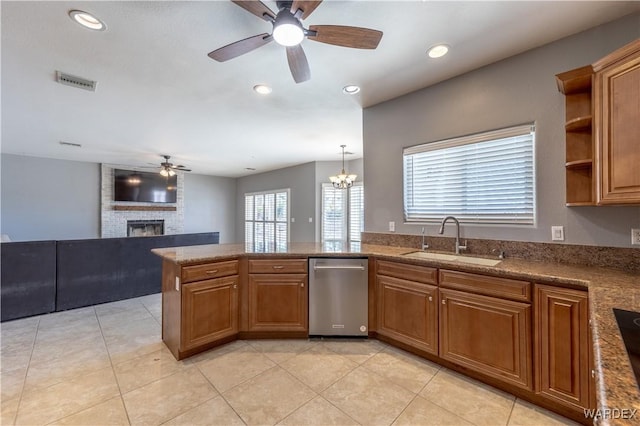 kitchen with visible vents, stainless steel dishwasher, brown cabinetry, a sink, and a peninsula