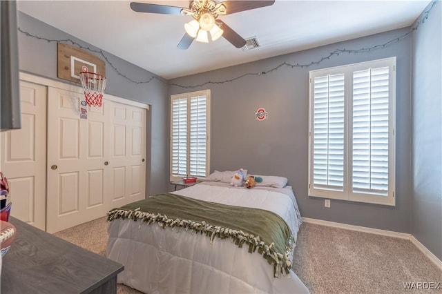 carpeted bedroom featuring a closet, visible vents, ceiling fan, and baseboards