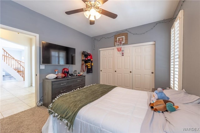 carpeted bedroom featuring ceiling fan and a closet