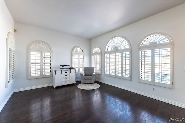 unfurnished room with a wealth of natural light, baseboards, and dark wood-style flooring