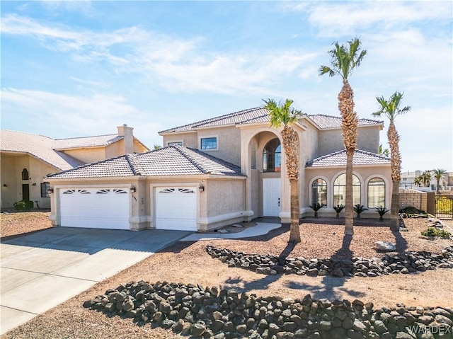 mediterranean / spanish-style home with stucco siding, concrete driveway, fence, a garage, and a tiled roof