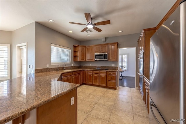 kitchen featuring light tile patterned flooring, a sink, appliances with stainless steel finishes, open shelves, and brown cabinetry