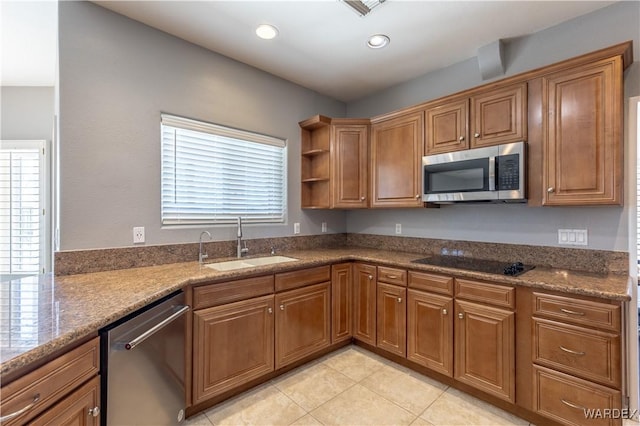 kitchen featuring appliances with stainless steel finishes, brown cabinets, and a sink