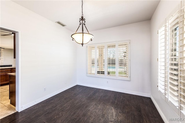 unfurnished dining area featuring wood finished floors, visible vents, and baseboards