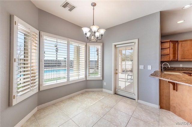 unfurnished dining area featuring light tile patterned floors, baseboards, visible vents, an inviting chandelier, and a sink