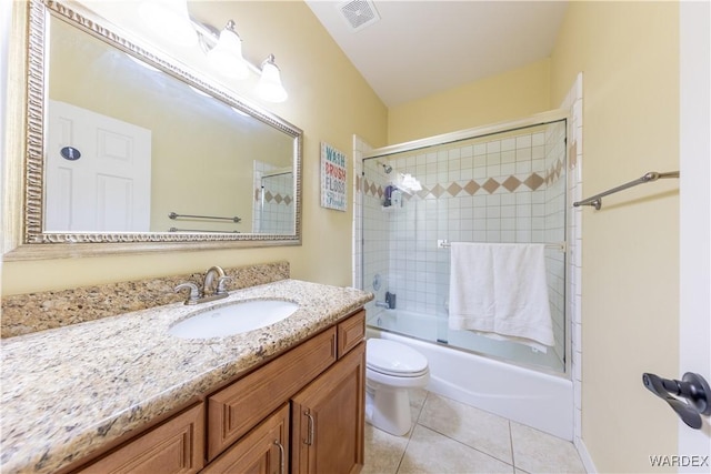 full bath with visible vents, toilet, combined bath / shower with glass door, vanity, and tile patterned flooring