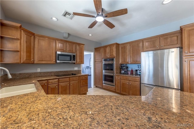 kitchen with brown cabinets, recessed lighting, visible vents, appliances with stainless steel finishes, and a sink