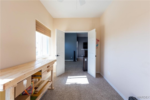 corridor featuring light carpet and baseboards